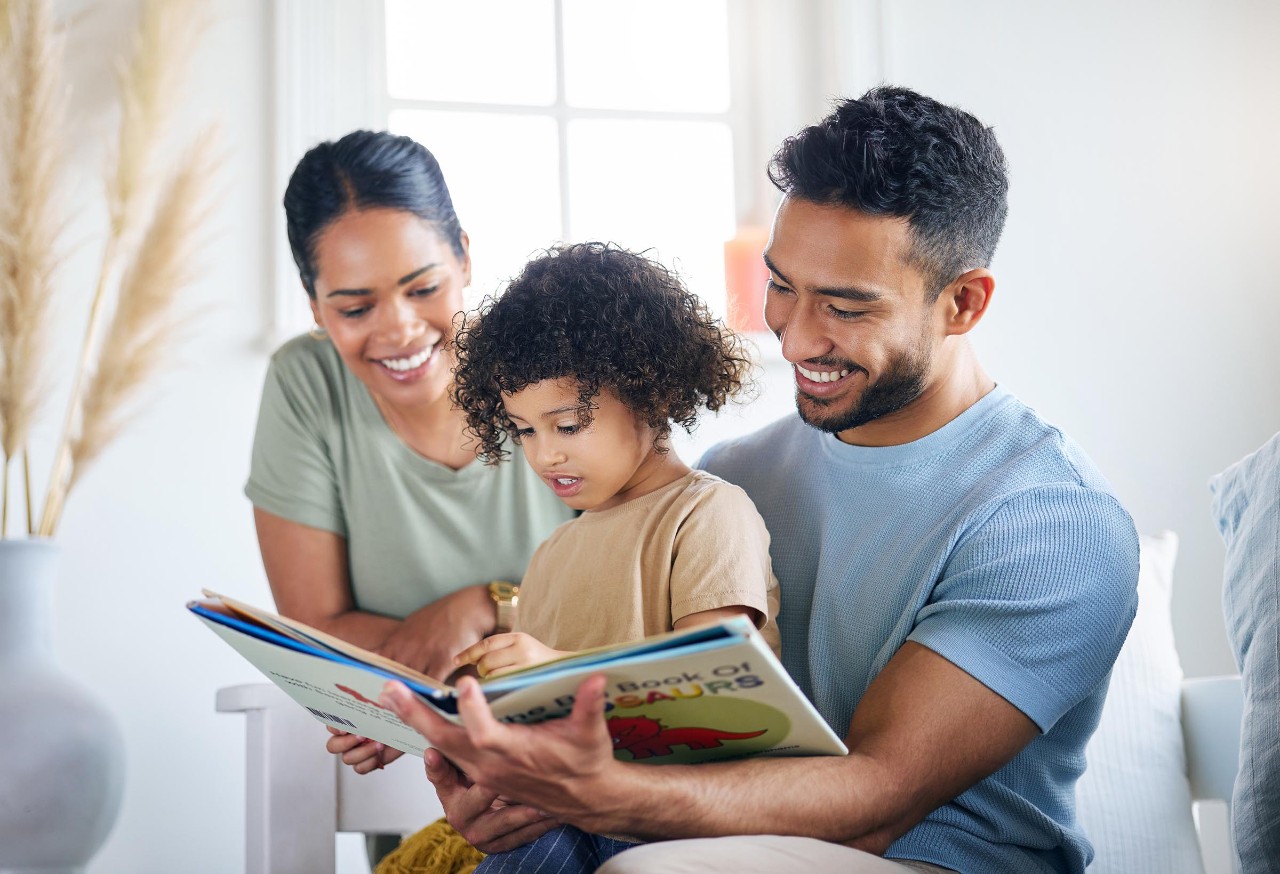 Parents and their young child reading a book together